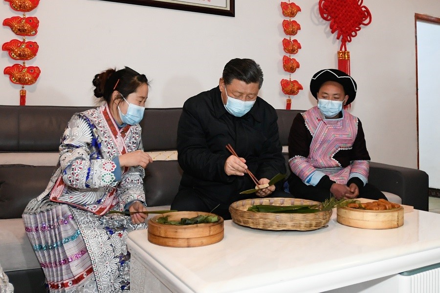 2021年2月3日下午，習(xí)近平在貴州畢節(jié)市黔西縣新仁苗族鄉(xiāng)化屋村苗族村民趙玉學(xué)家，同一家人邊聊家常邊制作當(dāng)?shù)貍鹘y(tǒng)節(jié)日食品黃粑。新華社記者 李學(xué)仁 攝
