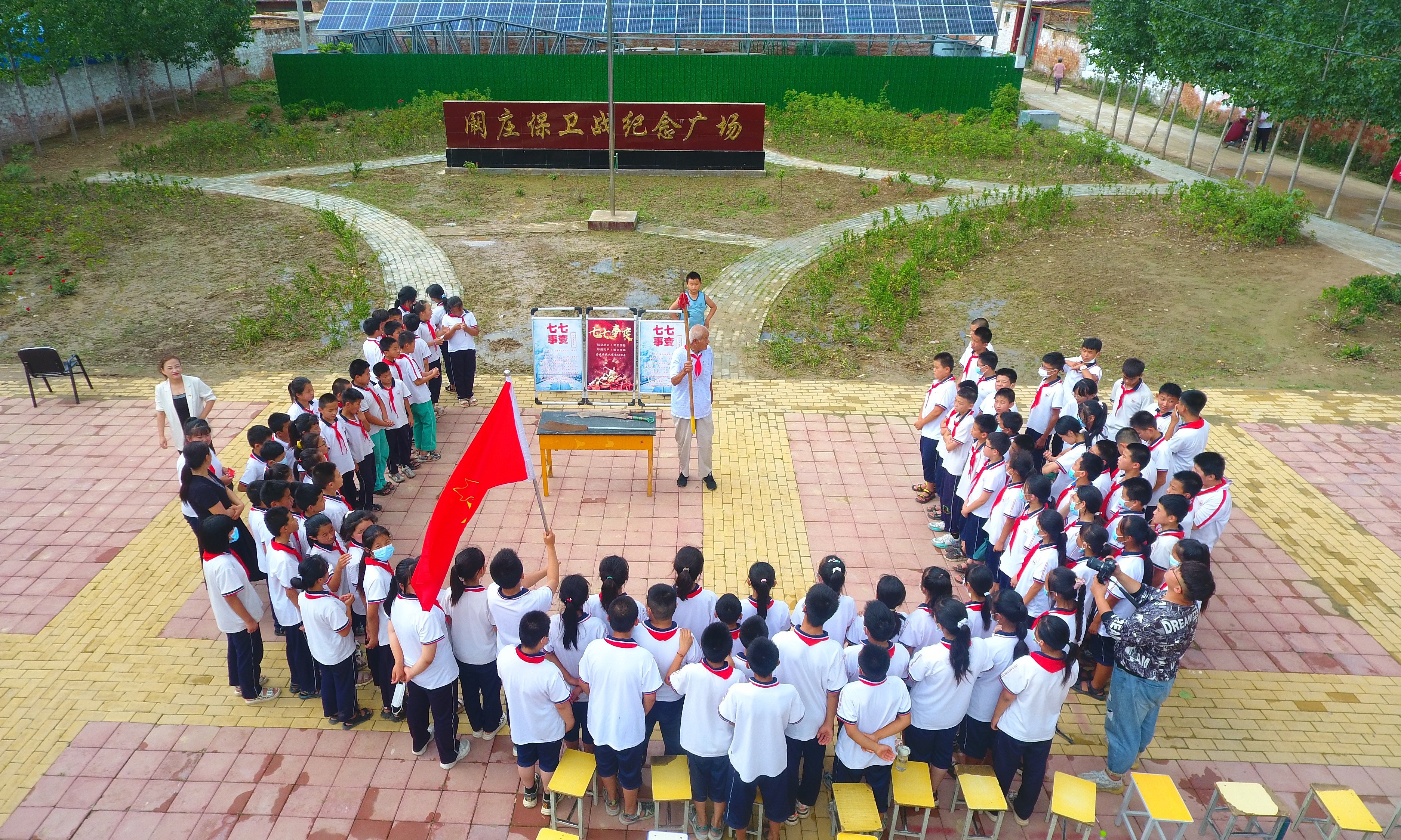 2022年7月6日，山東省聊城市，在茌平區(qū)菜屯鎮(zhèn)闞莊村的闞莊保衛(wèi)戰(zhàn)紀(jì)念廣場，闞莊保衛(wèi)戰(zhàn)親歷者王光木老人，為小學(xué)生們講述抗戰(zhàn)故事，展示大刀、長矛。
